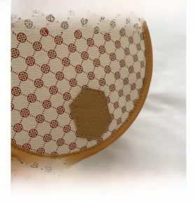 Close-up of vintage floral saddle bag with brown leather trim and hexagon patch