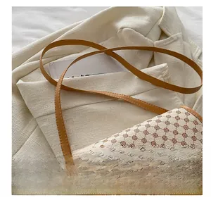Detail of comfortable brown leather shoulder strap on a vintage floral saddle bag
