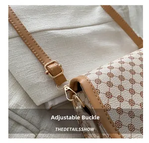 Detail of adjustable golden buckle and vintage clover print on saddle bag strap
