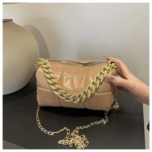 Detail of khaki quilted pillow bag with chunky gold chain handle and PU leather texture