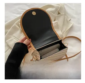 Detail view of the interior capacity showing a phone and lipstick inside the saddle bag