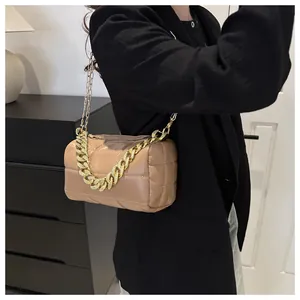 Close-up of khaki quilted cylinder bag featuring a bold chunky gold chain handle detail