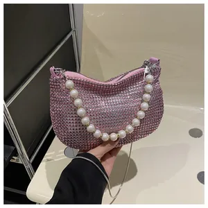 Detailed macro of pink rhinestone surface with large pearl handle on the crescent bag