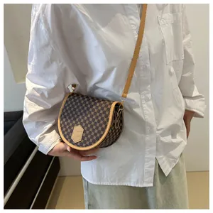 Close-up of a vintage saddle bag with geometric patterns worn with a casual outfit