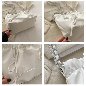 Detailansicht der weißen Schultertasche mit Falten, Schleifen und silberner Kette
