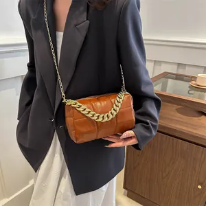 Brown quilted crossbody pillow bag with chunky gold chain handle and slim shoulder strap