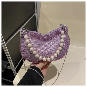 Close-up of purple rhinestone crescent bag with pearl handle and metal chain strap