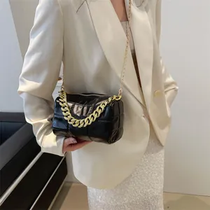 Quilted black cylinder pillow bag with bold gold chain straps for women's crossbody wear