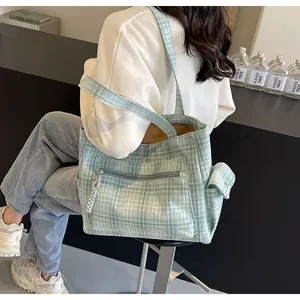 Close-up of mint green checkered canvas tote bag with functional front zipper pocket