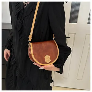 Detail of vintage brown saddle bag showing rich leather texture and contrast stitching