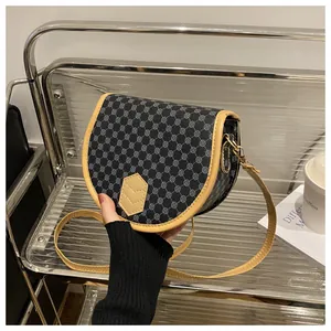 Detailed macro view of the vintage monogram saddle bag with yellow leather piping