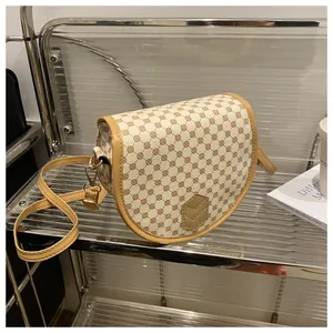 Close-up of vintage saddle bag with brown geometric patterns and golden metal hardware details