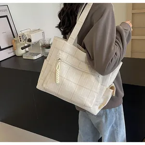 Detail view of large checkered canvas tote bag with functional front zipper pocket