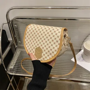 Vintage printed saddle bag with brown geometric patterns and adjustable shoulder strap