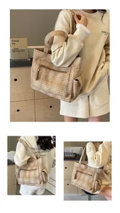 Detail of a large capacity plaid tote bag with side flap pockets and sturdy top handles