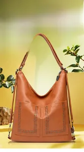 Dettaglio della borsa a tracolla in pelle PU marrone con borchie argento e grana martellata