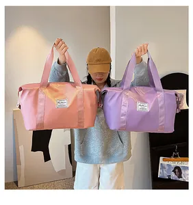 Detail of large nylon travel bags in pink and lilac with Fashion label and webbing handles