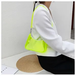 Détail du sac sous le bras en PVC transparent vert fluo sur mannequin en blazer blanc