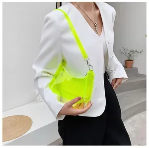 Gros plan d'un sac transparent en PVC jaune néon avec boucles argentées sur un mannequin