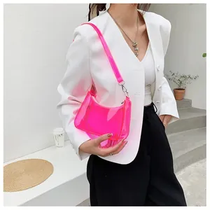 Sac à bandoulière en PVC rose néon transparent porté avec un blazer blanc moderne