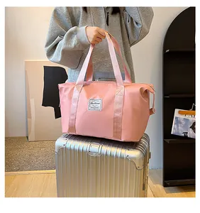 Pink nylon travel bag detail featuring reinforced handles and stylish Fashion patch