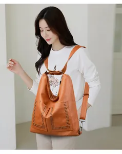 Dettaglio zaino in pelle PU marrone arancio con rivetti vintage e trama a grana