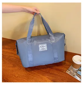 Close-up of a blue-gray waterproof nylon travel bag with a stylish fabric label