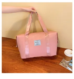 Detail of pink waterproof nylon travel bag with Fashion tag held by female hand