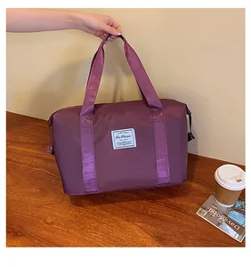 Detailed view of durable purple nylon travel bag with wide handles and reinforced stitching