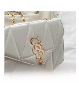 Détail d'un sac en cuir matelassé blanc avec logo SS doré, franges et bandoulière chaîne