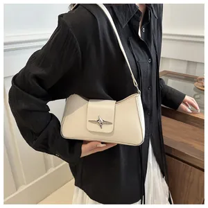 Détail du sac sous l'aisselle minimaliste blanc cassé avec un ornement de boucle étoile argentée