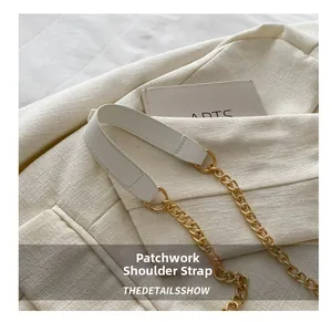 Détail de la bandoulière en cuir blanc avec chaîne en métal doré et surpiqûres fines