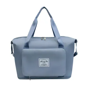 Detail of the light blue waterproof travel bag showing double metal zippers and side pocket