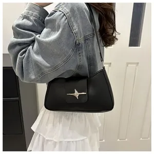 Détail du sac bandoulière en cuir PU noir avec une boucle métallique en forme d'étoile