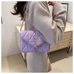 Détail du sac matelassé violet clair avec logo doré et accents de glands élégants
