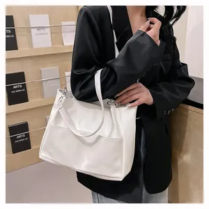 White large capacity tote bag with smooth matte finish worn by model in a stylish setting