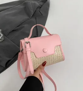 Detailaufnahme der rosa Leder- und Stroh-Kontrastnähte am Schultergurt der Handtasche