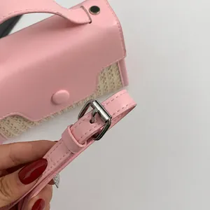 Details des verstellbaren rosa Schultergurts mit Schnalle an der Stroh-Tasche