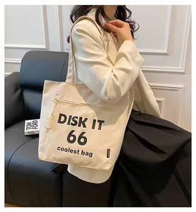 Detail of canvas tote bag with Disk It 66 print and zipper pocket worn by a model