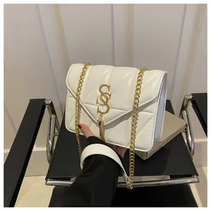 Détail d'un sac bandoulière matelassé blanc avec logo doré, glands et bandoulière chaîne