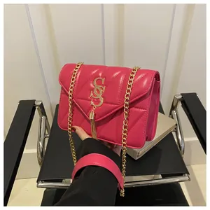 Détail du sac à bandoulière matelassé rouge rose avec logo SOS doré et pampille