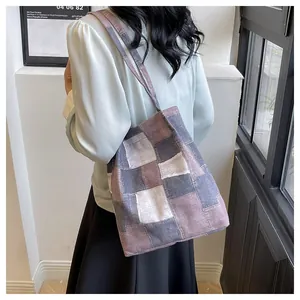 Detail of multi-color patchwork canvas tote bag showing texture and stitching on shoulder