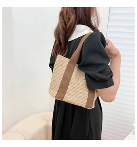 Straw shoulder bag worn by a model in a summer outfit, showing casual style and size