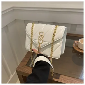 Détail du sac à rabat matelassé en V blanc avec logo doré et pompon en métal chic