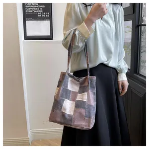 Detail of checkered canvas tote bag showing the textured fabric and earth-tone patchwork