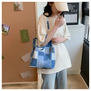 Detail of blue patchwork denim tote bag showing fabric texture and casual stitching