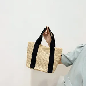 Minimalist straw tote bag with black handles, elegant woven beach handbag for women