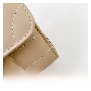 Detailed macro view of beige leather fabric with clean white contrast stitching patterns