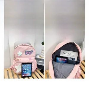 Detail view of pink school backpack showing spacious interior compartments for tablets