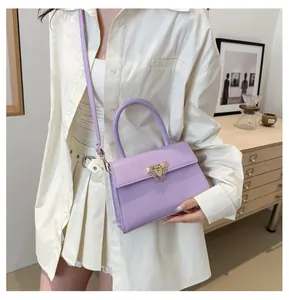 Detail view of lavender square handbag with gold buckle and stylish chain strap